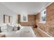 Bright bedroom features an exposed brick wall, hardwood floors, and bench seating at 1210 E Colfax Ave # 104, Denver, CO 80218