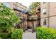 Charming courtyard view with staircases, wrought iron railings, brick walls, and lush greenery at 1210 E Colfax Ave # 104, Denver, CO 80218
