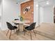 Inviting dining area features a modern table, black chairs, and exposed brick wall at 1210 E Colfax Ave # 104, Denver, CO 80218