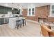 Bright, updated kitchen features stainless appliances, pendant lighting, breakfast bar, and exposed brick at 1210 E Colfax Ave # 104, Denver, CO 80218