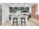 Modern kitchen boasts an island with seating, gray cabinets, updated appliances, and stylish pendant lighting at 1210 E Colfax Ave # 104, Denver, CO 80218