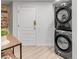 Convenient laundry area features stacked washer and dryer, and a white door at 1210 E Colfax Ave # 104, Denver, CO 80218