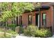 Charming brick townhouse with lush landscaping and a cozy front patio and black metal fence at 771 24Th St, Denver, CO 80205