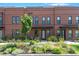 A beautiful brick townhouse with a landscaped front yard filled with colorful flowers at 771 24Th St, Denver, CO 80205