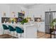 Modern kitchen featuring white cabinets, a tile backsplash, stainless steel appliances, and a large island with bar seating at 771 24Th St, Denver, CO 80205