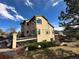 Tan house with large windows and deck, surrounded by trees at 3891 Windchant Cir, Castle Rock, CO 80104