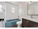 Bathroom with blue bathtub, white tile and vanity with a mirror at 8074 Grove St, Westminster, CO 80031