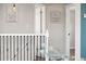 An upstairs hallway with art, white railing, black balusters, and open doors at 8074 Grove St, Westminster, CO 80031