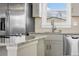 Close-up of kitchen featuring stainless steel refrigerator, gray cabinets and granite countertops at 8074 Grove St, Westminster, CO 80031