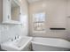 Serene bathroom featuring a freestanding soaking tub, pedestal sink, and a window view at 4225 W 30Th Ave, Denver, CO 80212