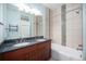 Bathroom features a double sink vanity with granite countertop and a shower-tub combo with decorative tile accents at 4225 W 30Th Ave, Denver, CO 80212