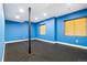 Bright blue finished basement, featuring an accent pole, rubber flooring, and natural light through the windows at 4193 W 99Th Ct, Westminster, CO 80031