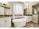 Elegant bathroom featuring soaking tub, separate vanities, walk-in shower, and herringbone pattern floors at 4193 W 99Th Ct, Westminster, CO 80031