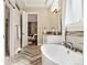 Bright bathroom with soaking tub, herringbone floors, and access to main bedroom and walk-in closet at 4193 W 99Th Ct, Westminster, CO 80031