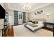 Spacious main bedroom featuring hardwood floors, tray ceiling, modern chandelier, and designer wall paper at 4193 W 99Th Ct, Westminster, CO 80031