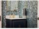 Elegant powder room with blue patterned wallpaper, gold fixtures, and marble countertop at 4193 W 99Th Ct, Westminster, CO 80031