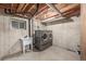 Unfinished basement featuring concrete walls, laundry area with a washer, dryer, and utility sink at 5316 S Jellison St, Littleton, CO 80123