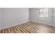 Bright bedroom featuring wood-look flooring, neutral walls, and a window for natural light at 5316 S Jellison St, Littleton, CO 80123