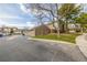 View of a townhome showing the garages, side door, and lawn from the street at 5316 S Jellison St, Littleton, CO 80123