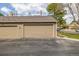 Attached two-car garage with a brown door, set in a well-kept neighborhood with mature trees at 5316 S Jellison St, Littleton, CO 80123