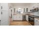 Bright kitchen featuring white cabinets, stainless steel appliances, and hardwood floors at 5316 S Jellison St, Littleton, CO 80123