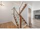 Bright foyer with staircase featuring wood railing, white spindles, and carpeted steps at 5316 S Jellison St, Littleton, CO 80123