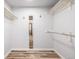 Walk-in closet with wood-look flooring, neutral walls, and shelving for storage at 5316 S Jellison St, Littleton, CO 80123