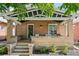 Inviting front porch with brick columns and a wooden swing at 1260 Adams St, Denver, CO 80206