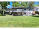 Lush backyard with mature trees, a deck, covered patio, and plenty of green space at 4545 S Lipan Ct, Englewood, CO 80110