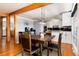 Open-concept dining area with wood floors and a modern chandelier at 4545 S Lipan Ct, Englewood, CO 80110