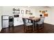 Stylish kitchen and dining area featuring modern appliances, a cozy seating area, and dark wood flooring at 4545 S Lipan Ct, Englewood, CO 80110