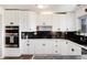 Modern kitchen with white cabinets, black hardware, and dark granite countertops at 4545 S Lipan Ct, Englewood, CO 80110