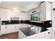 Bright kitchen featuring white cabinets, granite countertops, and stainless steel appliances at 4545 S Lipan Ct, Englewood, CO 80110