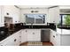 Well-lit kitchen with white cabinets, granite countertops, and a stainless steel dishwasher at 4545 S Lipan Ct, Englewood, CO 80110