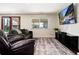 Inviting living room with a cozy sofa, large windows offering scenic views, and a modern entertainment center at 4545 S Lipan Ct, Englewood, CO 80110