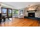 Cozy living room with fireplace, hardwood floors, and large windows leading to an outdoor deck at 4545 S Lipan Ct, Englewood, CO 80110