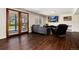 Comfortable living room with wood floors, a cozy sofa, fireplace, and access to outdoor patio with scenic views at 4545 S Lipan Ct, Englewood, CO 80110