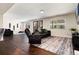 Spacious living room with dark wood floors, a comfortable sofa, recliner, and large windows allowing natural light at 4545 S Lipan Ct, Englewood, CO 80110