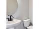 Modern bathroom with sleek fixtures, round mirror, and a clean white toilet at 8321 Mount Kataka St, Littleton, CO 80125