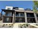 Modern townhomes with brick facade, private balconies, and manicured landscaping under a clear blue sky at 8321 Mount Kataka St, Littleton, CO 80125