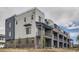 Exterior of new townhomes featuring brick and white siding, private balconies, and professional landscaping at 8321 Mount Kataka St, Littleton, CO 80125