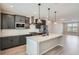 Modern kitchen featuring gray cabinets, stainless steel appliances, a spacious island and pendant lighting at 8321 Mount Kataka St, Littleton, CO 80125