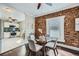 Chic dining area with a glass table and modern chairs, complemented by an exposed brick accent wall at 3956 Kalamath St, Denver, CO 80211