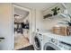 Laundry area showing modern washer and dryer, shelving, and an open doorway to the kitchen at 3956 Kalamath St, Denver, CO 80211