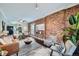 Inviting living room featuring exposed brick wall, modern decor, and an open concept to the dining area at 3956 Kalamath St, Denver, CO 80211