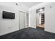 This bedroom has gray patterned carpet, a mounted tv, and a modern sliding door closet at 891 14Th St # 2105, Denver, CO 80202