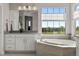 Bright bathroom features a large window with views, white cabinets, and a soaking tub at 11522 Trona Ct, Parker, CO 80138