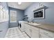 Modern laundry room with patterned floors, white cabinets and counters, and a 