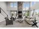 Spacious living room with soaring ceilings, a cozy stone fireplace, and plenty of natural light at 11522 Trona Ct, Parker, CO 80138