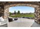 View of the patio with stone archway, stylish furniture, a round coffee table, and a grassy backyard at 11522 Trona Ct, Parker, CO 80138